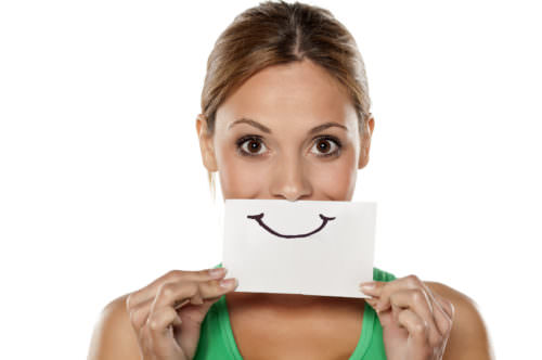 happy young woman with emotions drawn on a piece of paper